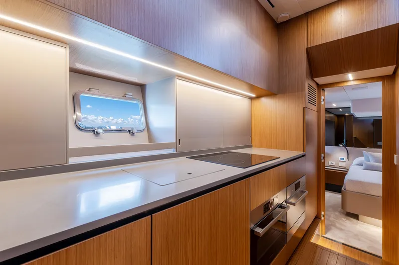  Yacht Photos Pics Luxurious interior of 2024 Bluegame 54 yacht featuring modern kitchen and cozy bedroom.