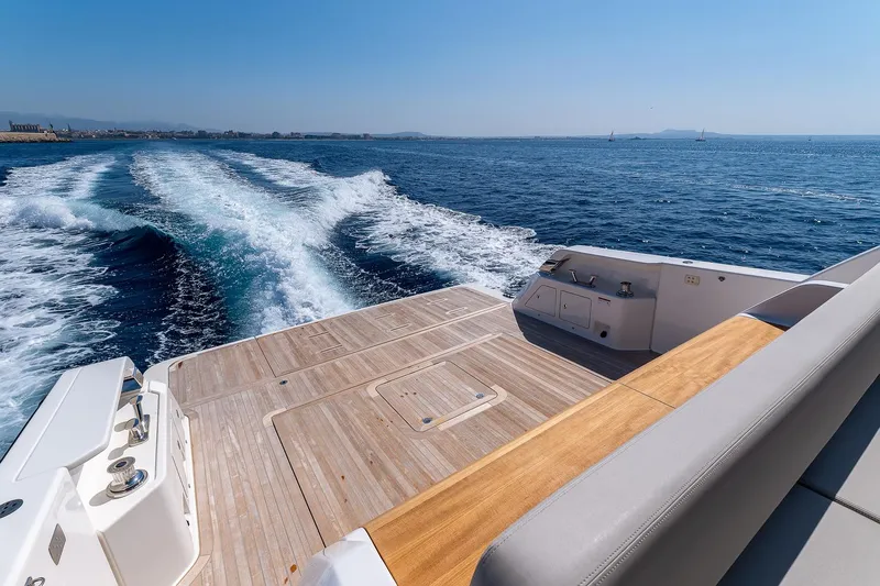  Yacht Photos Pics 2024 Bluegame 54 yacht cruising on open sea with wooden deck and wake trail.