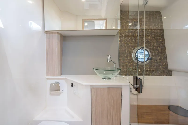 Custom Order Yours Today! Yacht Photos Pics Modern bathroom interior in 2025 Hanover 377 Outboard boat, featuring glass sink and porthole window.