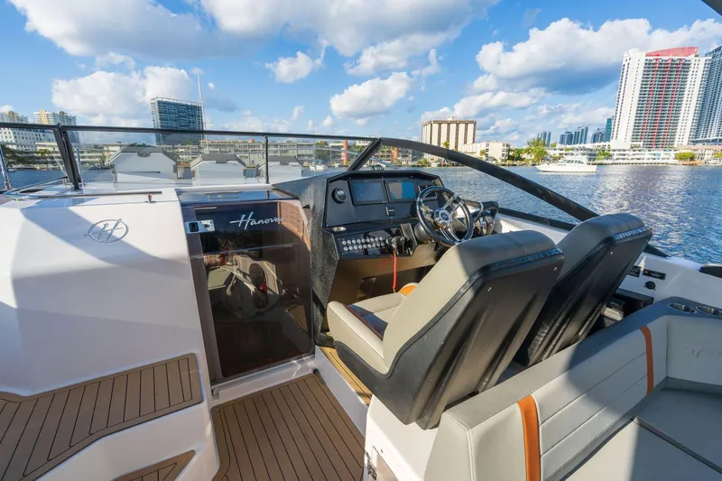 Custom Order Yours Today! Yacht Photos Pics 2025 Hanover 377 Outboard boat interior with modern dashboard and waterfront city view.