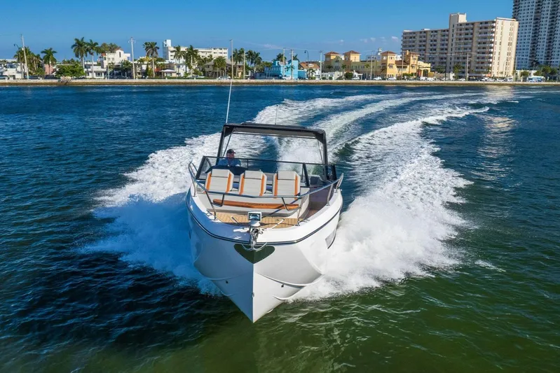 Custom Order Yours Today! Yacht Photos Pics 2025 Hanover 377 Outboard boat cruising on water near city skyline.