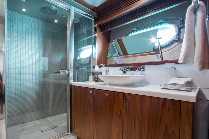 Marin Yacht Photos Pics Luxurious bathroom in 2014 Sunseeker 131 yacht with modern shower and wooden cabinetry.