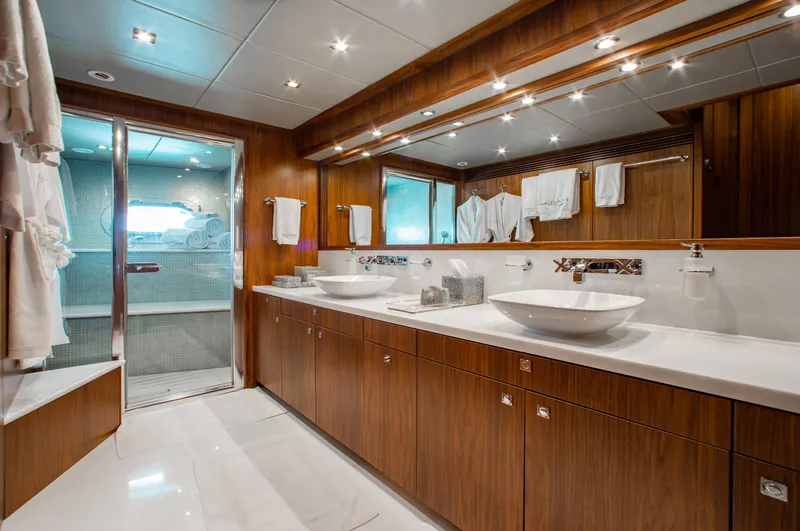 Marin Yacht Photos Pics Luxurious bathroom on a 2014 Sunseeker 131 yacht with dual sinks and wooden cabinetry.