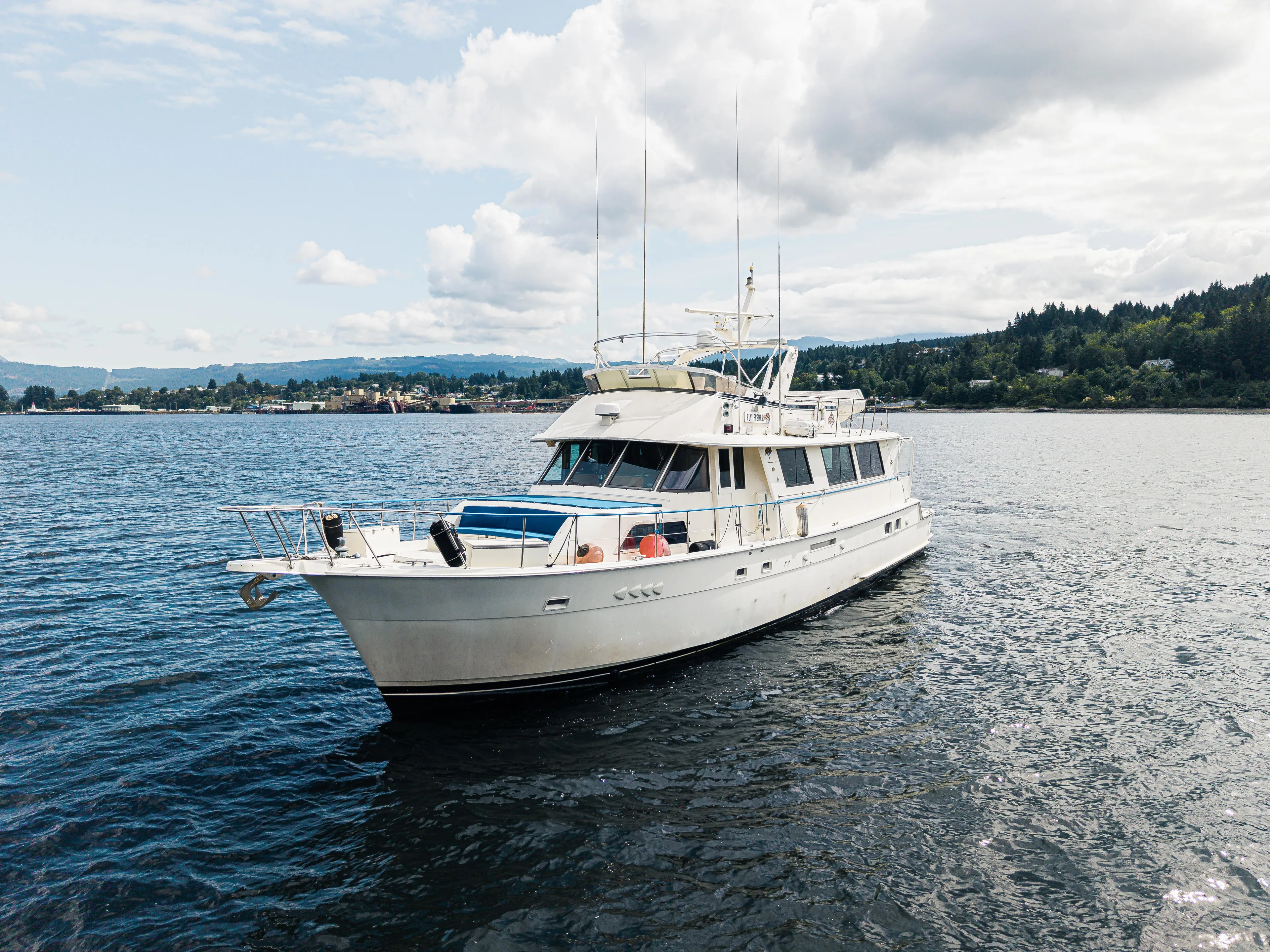  Yacht Photos Pics 1983 Hatteras Pleasure Craft yacht on calm water under a partly cloudy sky.