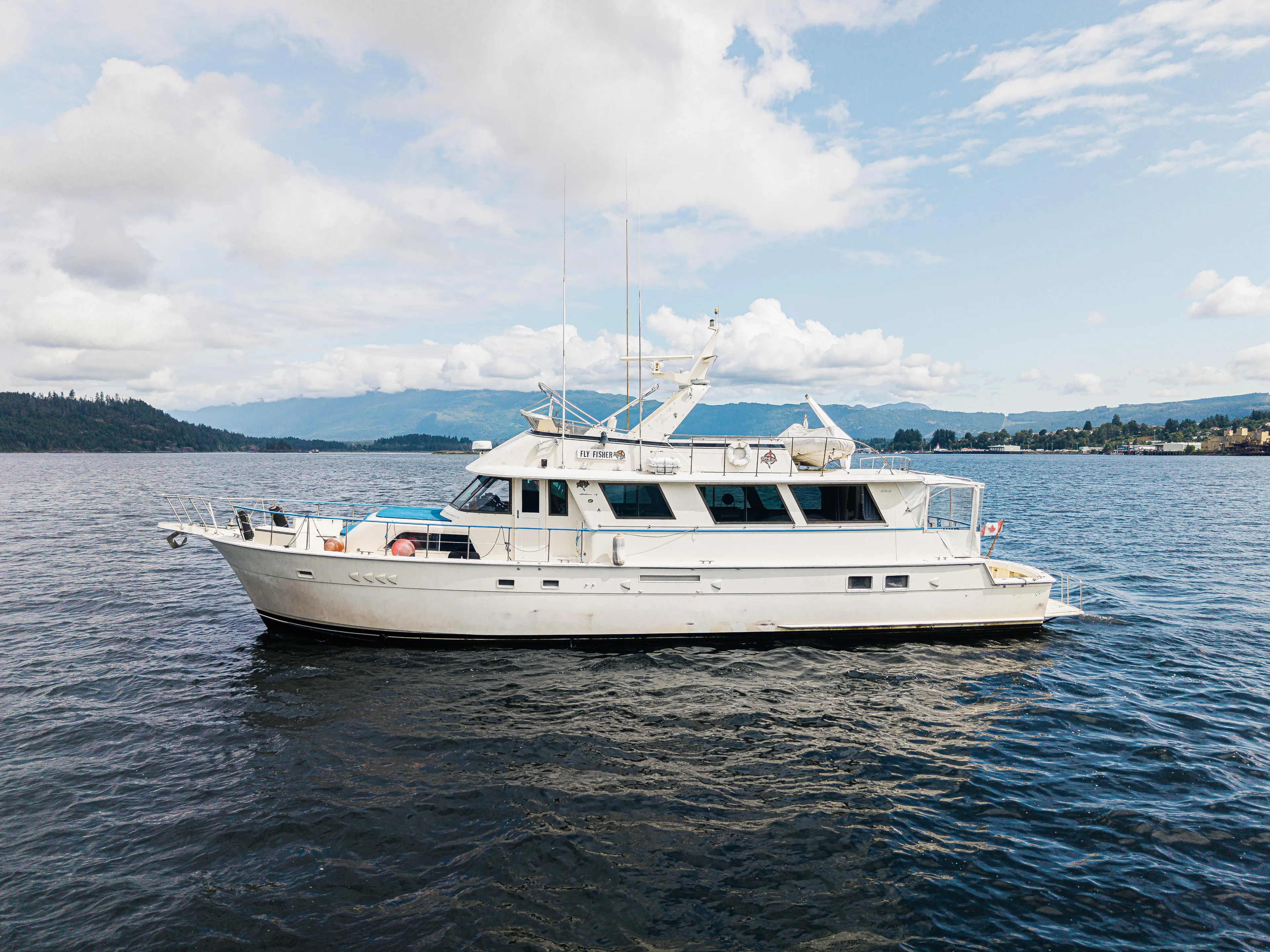  Yacht Photos Pics 1983 Hatteras Pleasure Craft on calm waters under a partly cloudy sky.