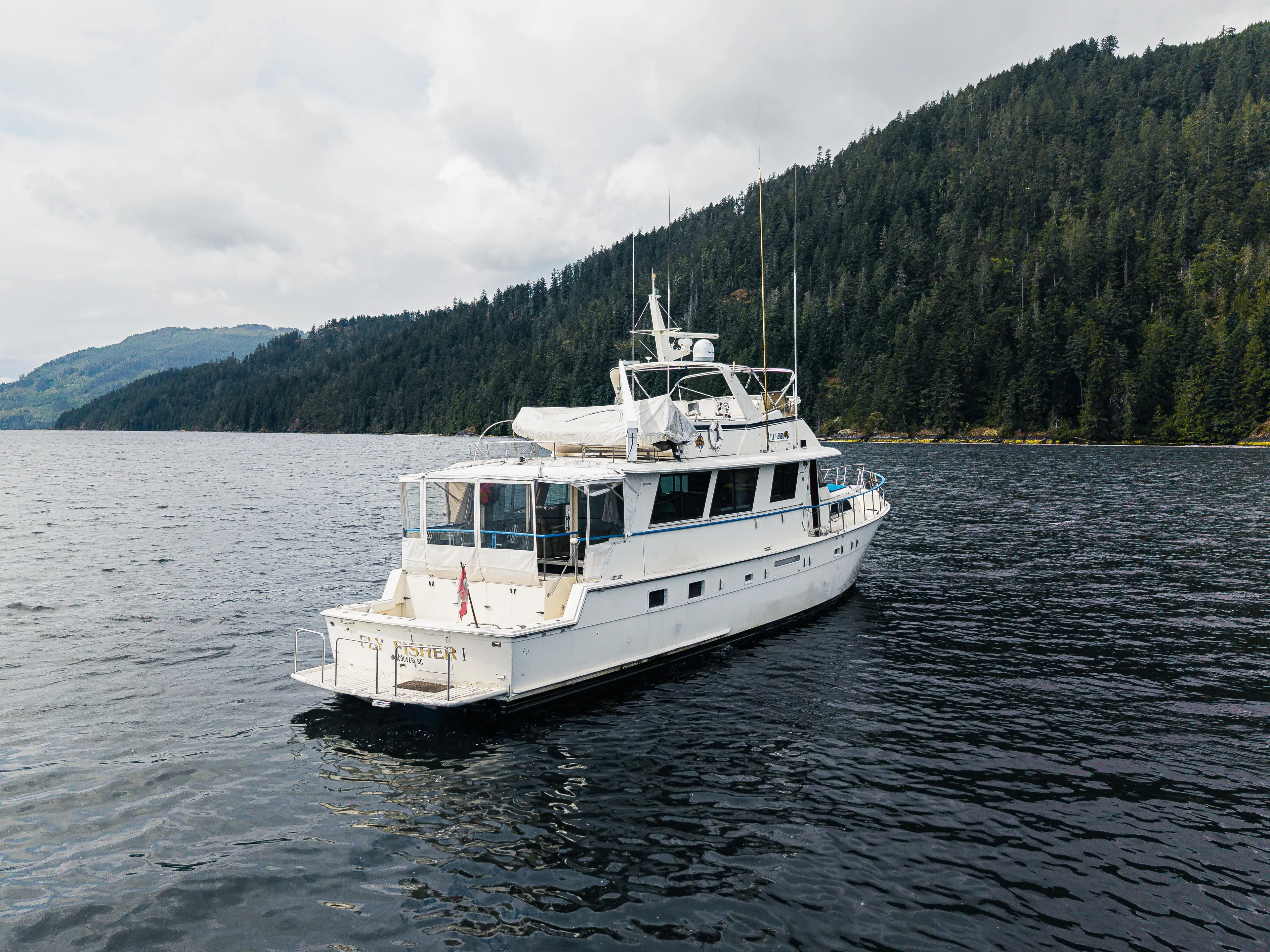  Yacht Photos Pics 1983 Hatteras Pleasure Craft on scenic lake with forested hills in background.