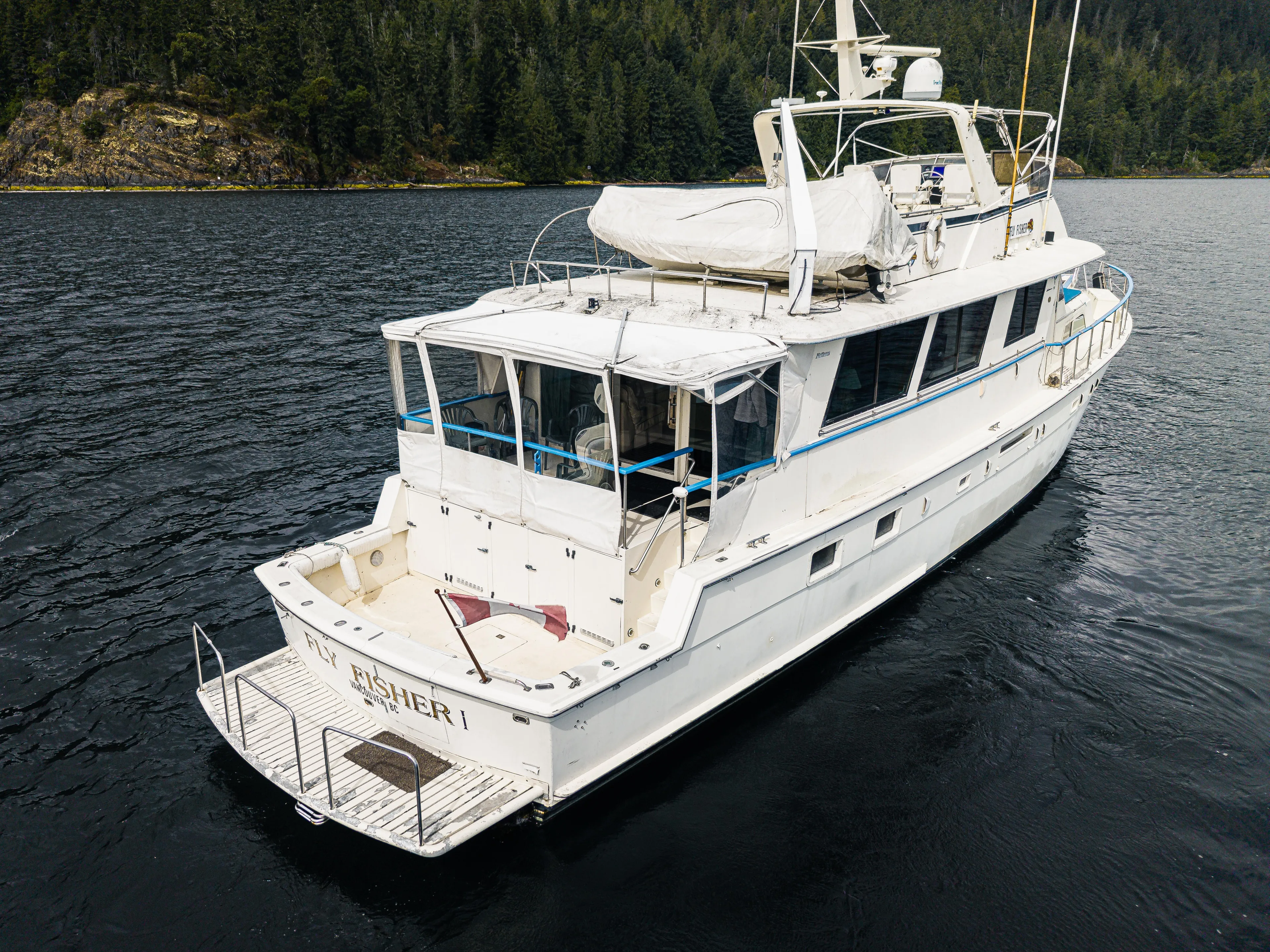  Yacht Photos Pics 1983 Hatteras Pleasure Craft on scenic water with forested shoreline.