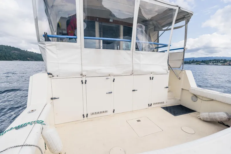  Yacht Photos Pics 1983 Hatteras Pleasure Craft on calm water, featuring spacious deck and enclosed cabin.