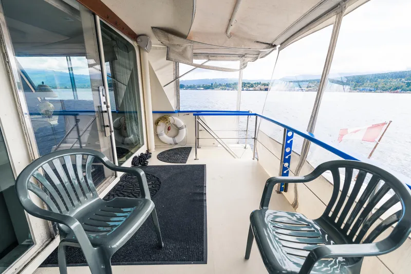  Yacht Photos Pics 1983 Hatteras Pleasure Craft deck with chairs, overlooking serene water and distant shoreline.