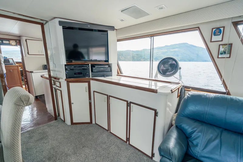  Yacht Photos Pics Interior of 1983 Hatteras Pleasure Craft with TV, seating, and scenic window view.