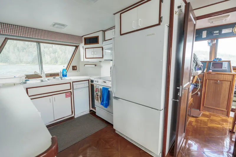  Yacht Photos Pics Interior of 1983 Hatteras Pleasure Craft kitchen with appliances and wood accents.