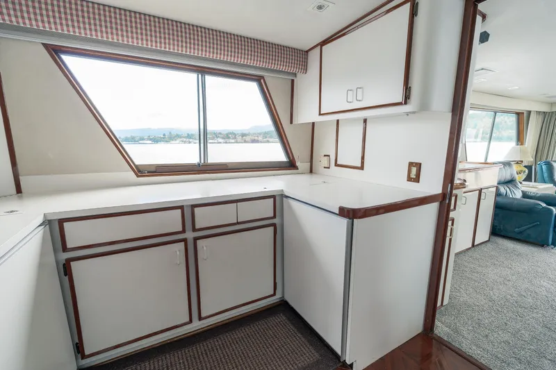 Yacht Photos Pics Interior of 1983 Hatteras Pleasure Craft with white cabinetry and large window view.