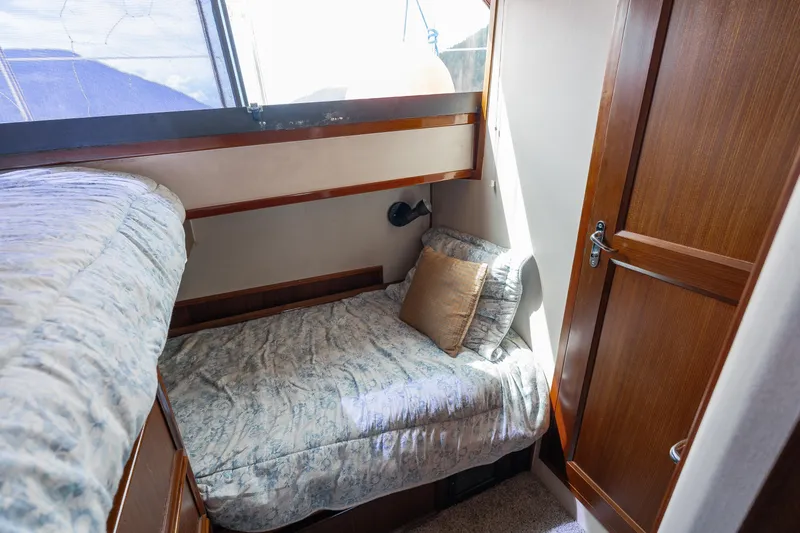  Yacht Photos Pics Cozy cabin interior of 1983 Hatteras Pleasure Craft with single bed and wooden accents.