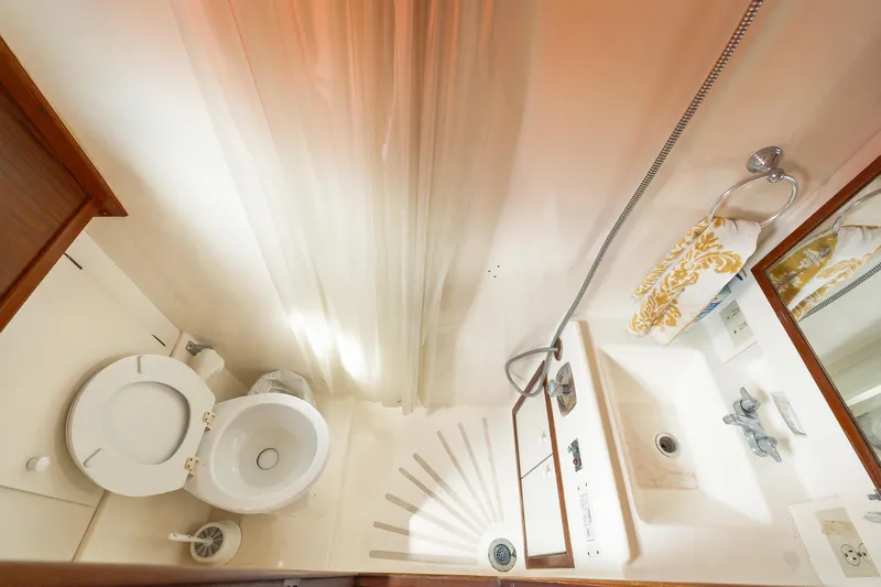  Yacht Photos Pics Bathroom interior of 1983 Hatteras Pleasure Craft with shower, sink, and toilet.