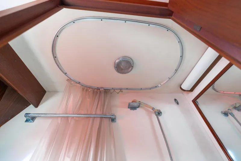 Yacht Photos Pics 1983 Hatteras Pleasure Craft bathroom with showerhead, curtain, and wooden accents.