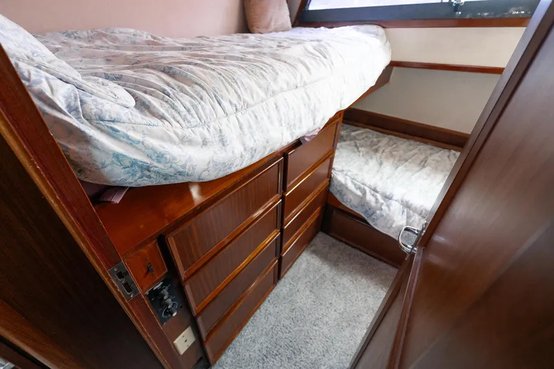  Yacht Photos Pics 1983 Hatteras Pleasure Craft cabin with bunk beds and wooden storage drawers.