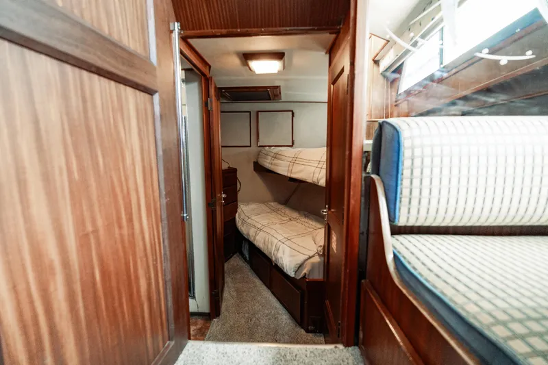  Yacht Photos Pics Interior of 1983 Hatteras Pleasure Craft with wooden paneling and bunk beds.