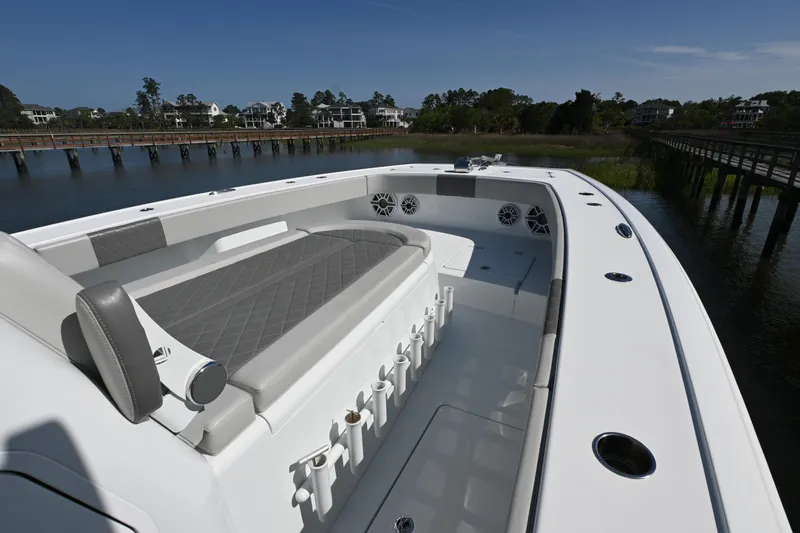  Yacht Photos Pics 2022 Freeman 37VH boat interior with seating and rod holders, docked by a scenic waterfront.