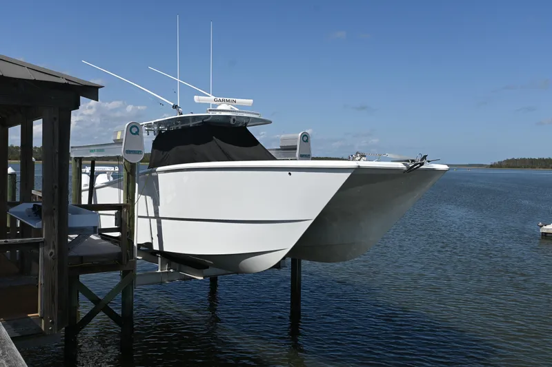  Yacht Photos Pics 2022 Freeman 37VH boat docked on a lift over calm water.