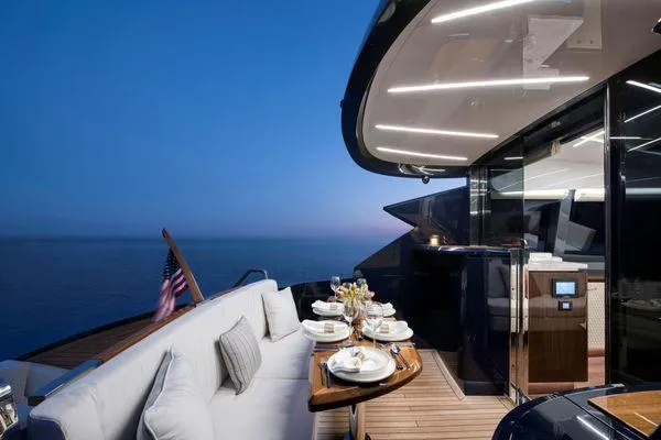  Yacht Photos Pics Luxurious 2023 Lazzara LSX yacht deck with elegant dining setup at sunset.