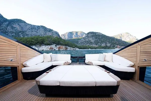  Yacht Photos Pics Luxurious 2023 Lazzara LSX yacht deck with plush seating, scenic mountain backdrop.