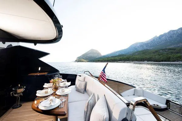  Yacht Photos Pics Luxury Lazzara LSX 2023 yacht with elegant dining setup, scenic ocean and mountain view.