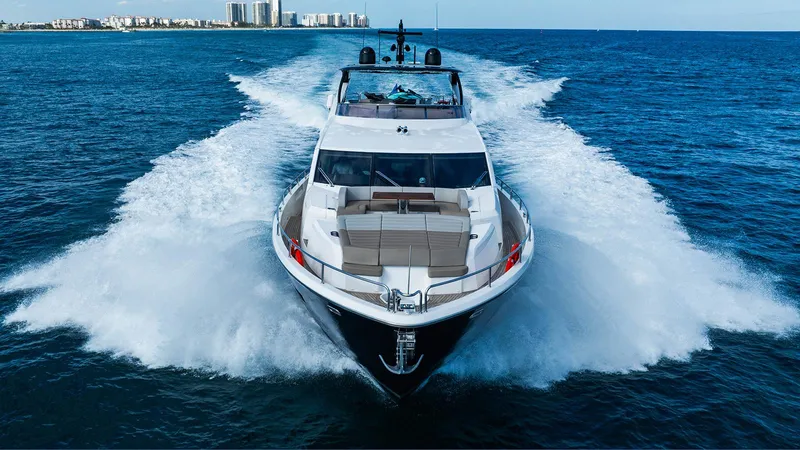 Golden Ours Yacht Photos Pics Luxurious 2019 Sunseeker Motoryacht cruising on open water, city skyline in background.