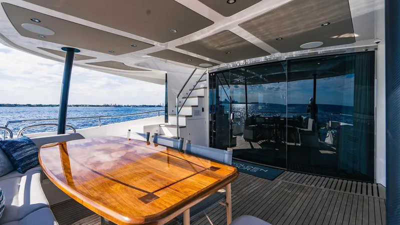 Golden Ours Yacht Photos Pics Luxurious 2019 Sunseeker Motoryacht deck with wooden table, ocean view, and modern design.