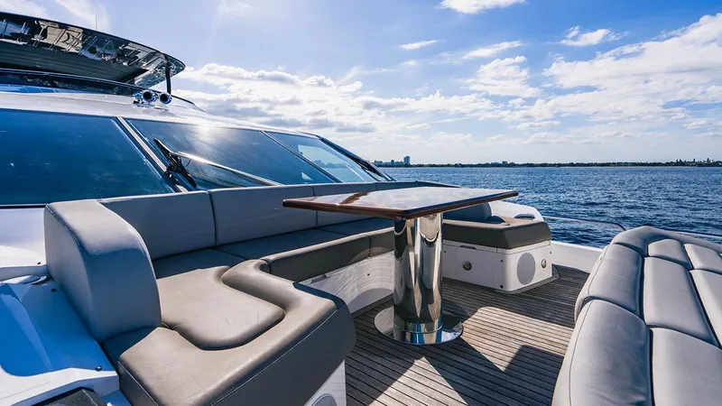 Golden Ours Yacht Photos Pics Luxurious 2019 Sunseeker Motoryacht deck with seating and table, overlooking serene ocean waters.