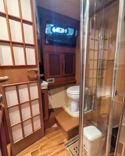  Yacht Photos Pics 2006 Mochi Craft 51 Dolphin yacht bathroom with wooden accents and glass shower enclosure.