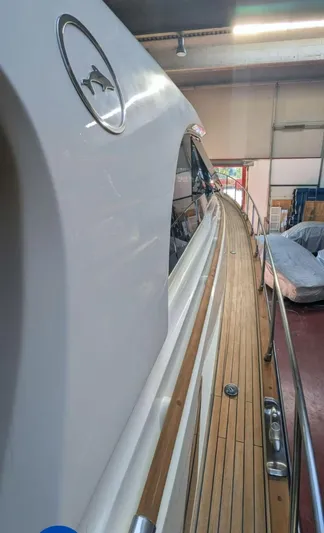  Yacht Photos Pics 2006 Mochi Craft 51 Dolphin yacht with sleek design and wooden deck in a storage facility.