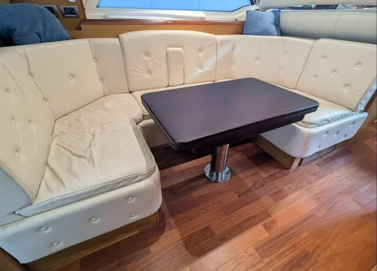  Yacht Photos Pics Luxurious beige leather seating with a wooden table on a 2006 Mochi Craft 51 Dolphin yacht.