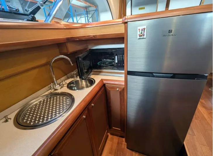  Yacht Photos Pics Kitchen area of 2006 Mochi Craft 51 Dolphin yacht with sink, microwave, and refrigerator.