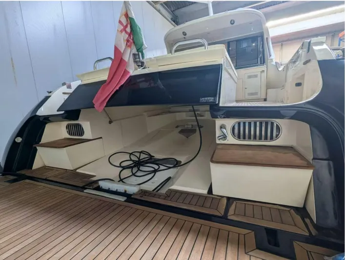  Yacht Photos Pics 2006 Mochi Craft 51 Dolphin yacht with open deck, wooden flooring, and flag displayed.