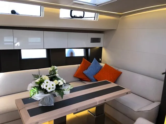 Manona (name Reserved For Owner) Yacht Photos Pics Luxurious interior of 2018 Beneteau Oceanis Yacht 62 with elegant seating and floral arrangement.