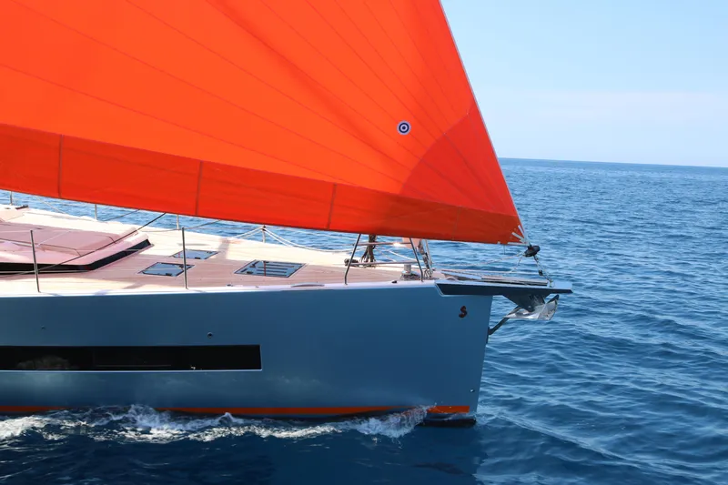 Manona (name Reserved For Owner) Yacht Photos Pics 2018 Beneteau Oceanis Yacht 62 with vibrant orange sail on open sea.