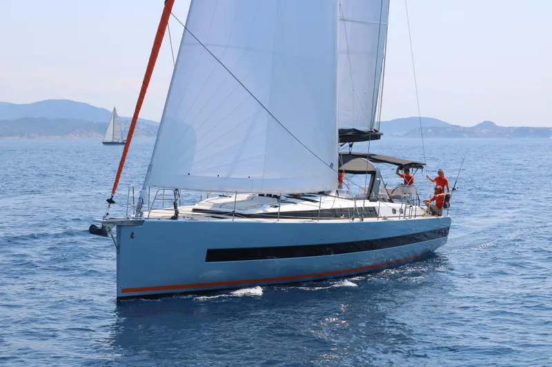 Manona (name Reserved For Owner) Yacht Photos Pics 2018 Beneteau Oceanis Yacht 62 sailing on open water with mountains in the background.