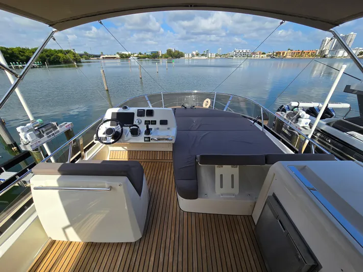  Yacht Photos Pics Flybridge of 2018 Prestige 460 yacht with seating, helm, and scenic waterfront view.