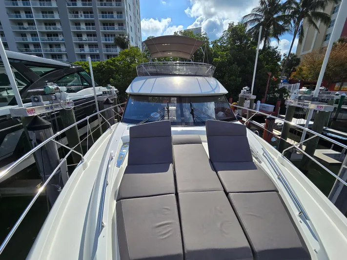  Yacht Photos Pics 2018 Prestige 460 yacht with sun loungers, docked near palm trees and buildings.