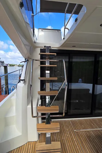  Yacht Photos Pics Staircase on 2018 Prestige 460 yacht, leading to upper deck with glass doors and wooden flooring.