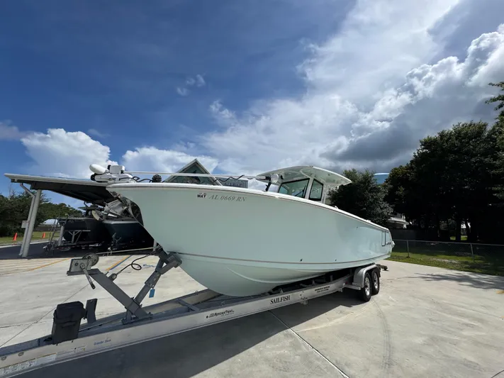  Yacht Photos Pics 2023 Sailfish 312 CC boat on trailer under cloudy sky.