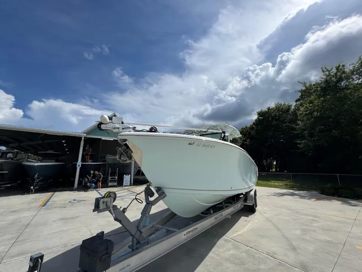  Yacht Photos Pics 2023 Sailfish 312 CC boat on trailer under cloudy sky.