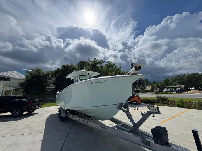  Yacht Photos Pics 2023 Sailfish 312 CC boat on trailer under cloudy sky.