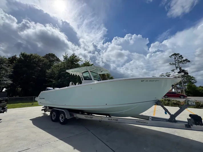  Yacht Photos Pics 2023 Sailfish 312 CC boat on trailer under cloudy sky.