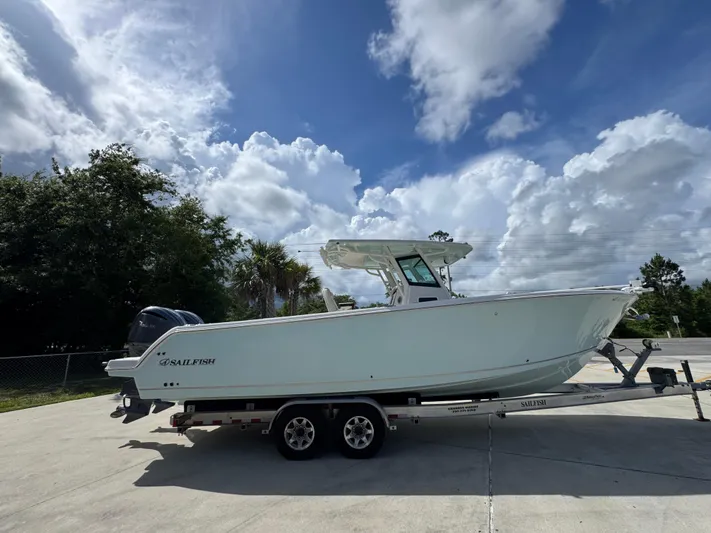  Yacht Photos Pics 2023 Sailfish 312 CC boat on trailer under cloudy sky.