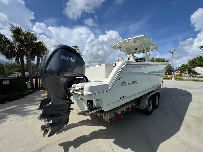  Yacht Photos Pics 2023 Sailfish 312 CC boat with Yamaha engine on trailer, parked outdoors.