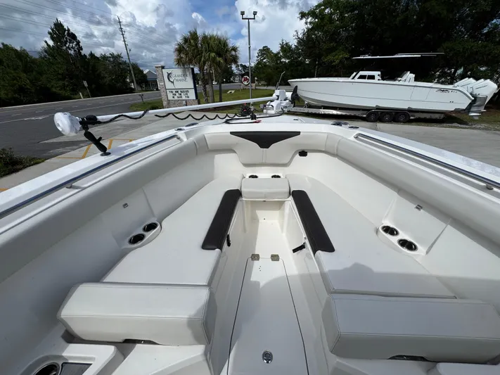 Yacht Photos Pics 2023 Sailfish 312 CC boat interior with seating and cup holders, parked outdoors.