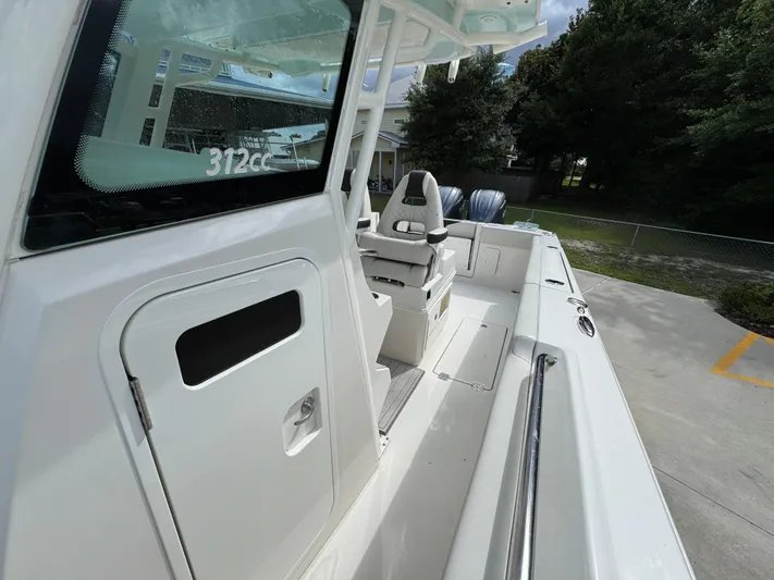  Yacht Photos Pics 2023 Sailfish 312 CC boat interior with seating and console, docked outdoors.