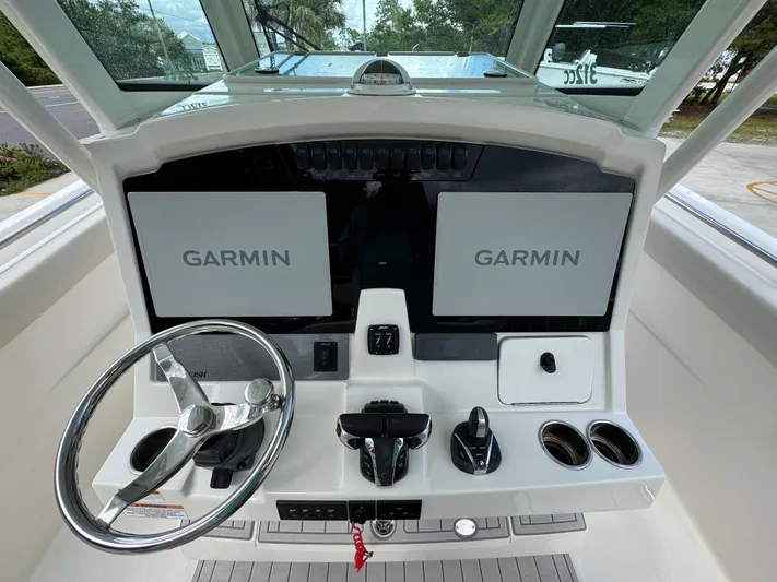  Yacht Photos Pics 2023 Sailfish 312 CC boat dashboard with dual Garmin displays and steering wheel.