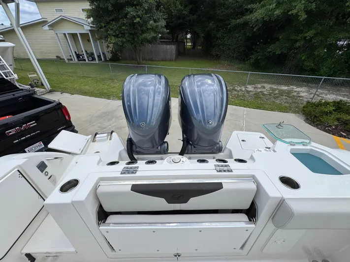  Yacht Photos Pics 2023 Sailfish 312 CC boat with dual outboard engines, parked near a GMC truck.
